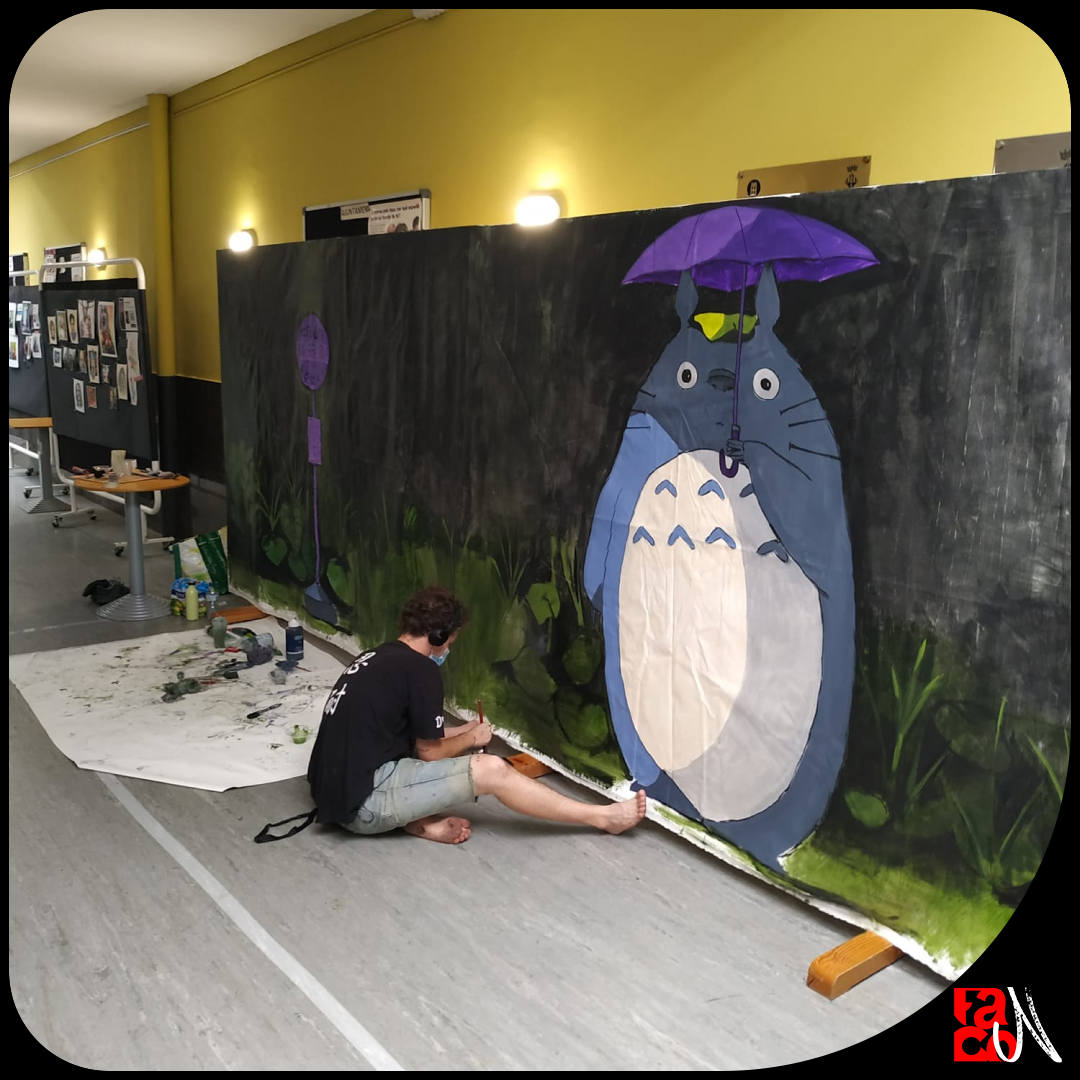Home pintant un mural amb la figura del Totoro